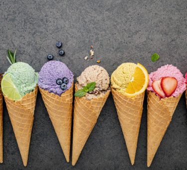 Flat lay ice cream cones collection on dark stone background . B